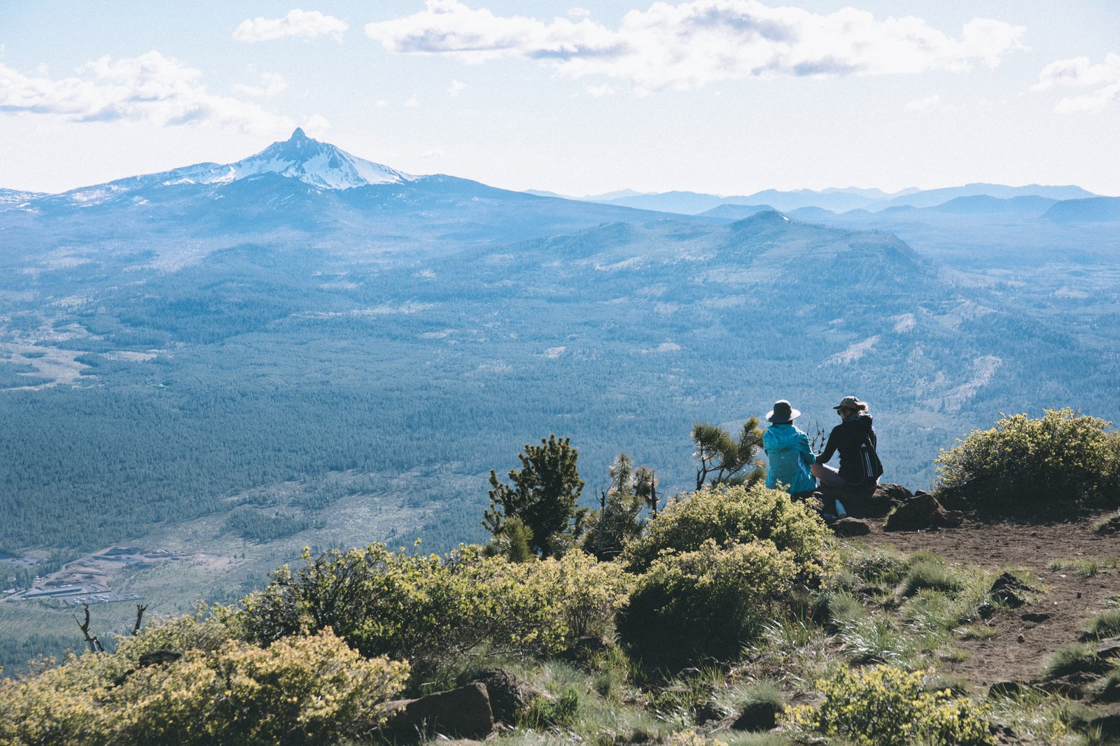 Two digital nomads hiking in Bend, Oregon, enjoying a flexible lifestyle while working on a remote team.